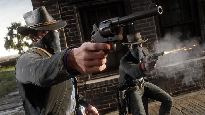 In-game image from Red Dead Redemption 2 of two characters wearing cowboy hats with their faces covered firing pistols.