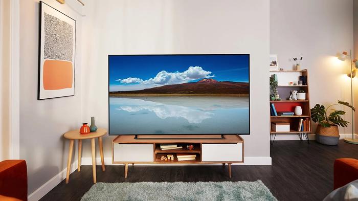 Image of a Samsung TV with a beach and mountain on the display in a living room.